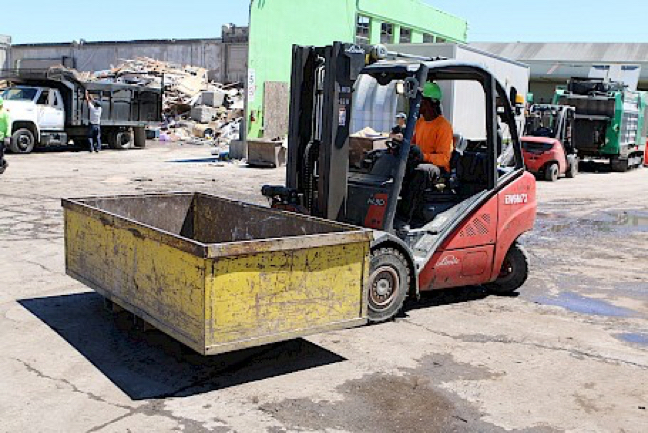 Forklift with rotator attachment and bin